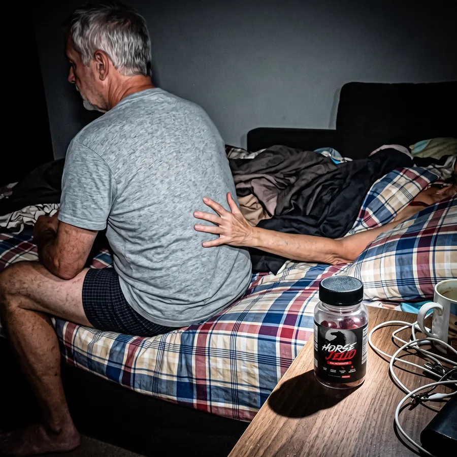James K. on the edge of the bed, his wife reaching for him